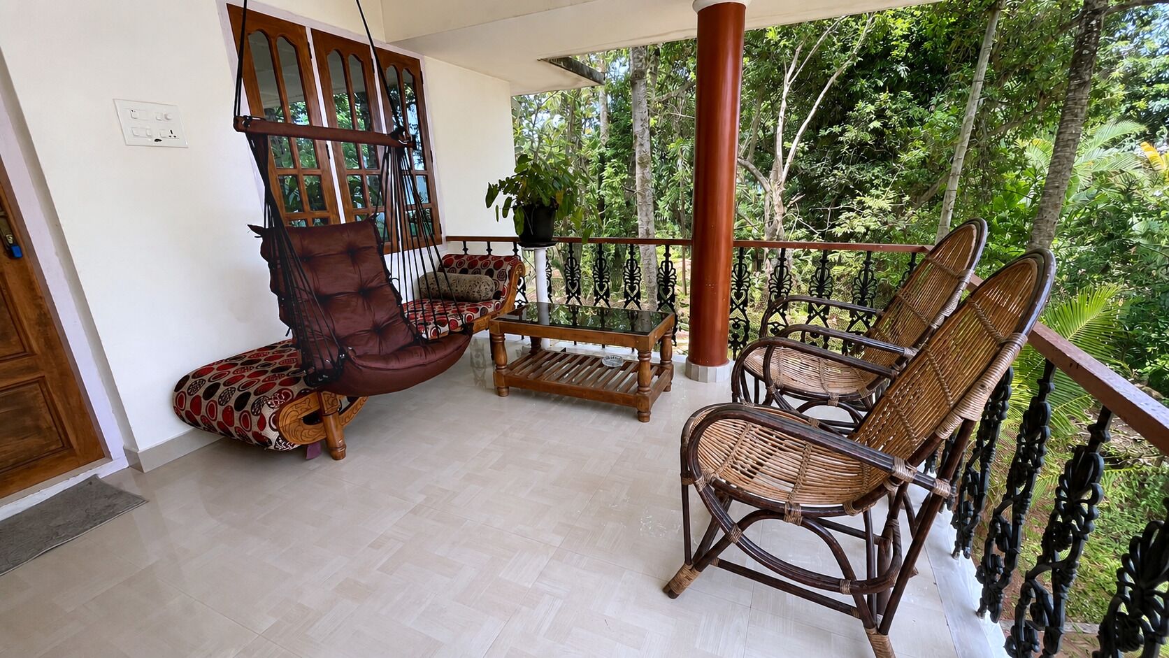 Un balcon agrémenté de meubles en osier, d’un fauteuil rembourré et d’une table.