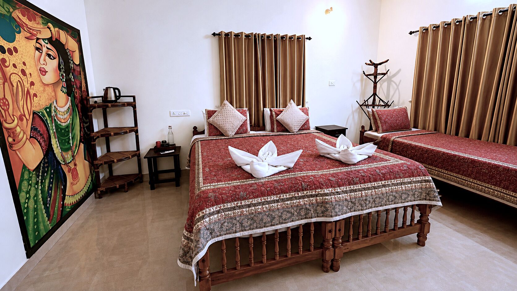 A hotel room with a large bed, a smaller bed, a wooden chair, a nightstand, a lamp, and a painting on the wall.