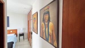A hallway with a bed, a nightstand, and two paintings on the wall. - 1806 (Rio de Janeiro)