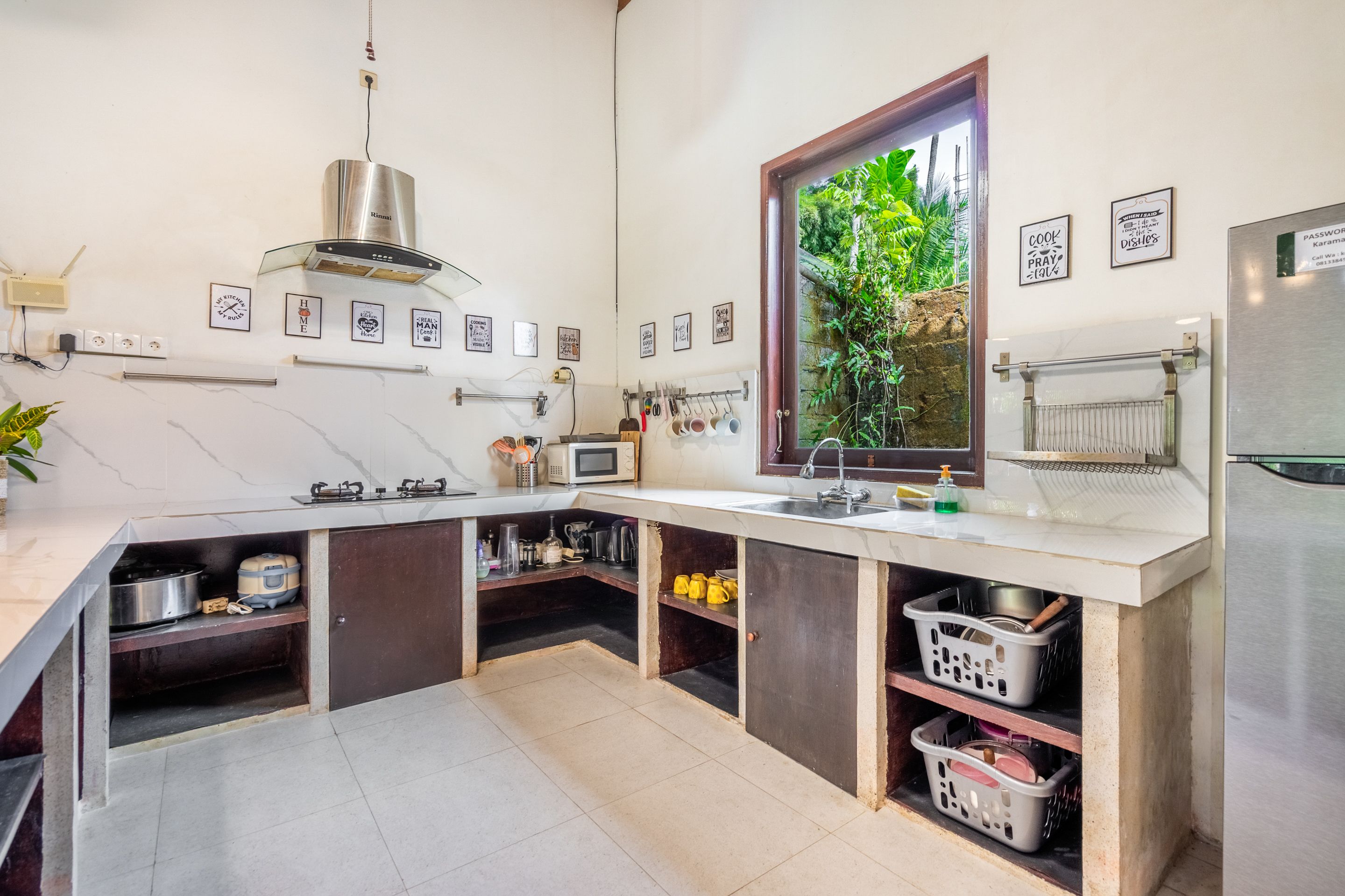 Een moderne keuken met een inbouwfornuis, een spoelbak en een raam met uitzicht op groen.