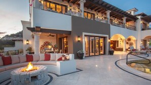 A two-story building with a patio area featuring a fire pit, outdoor seating, and a pool. - Fundadores 121 - Puerto Los Cabos (San Jose Del Cabo)