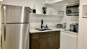 A modern kitchen with stainless steel appliances, wooden cabinets, and white countertops. - Private 1BR Suite w Full Kitchen & Laundry (Hayward)