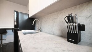 Uma cozinha moderna com bancada de mármore, pia e porta-facas.