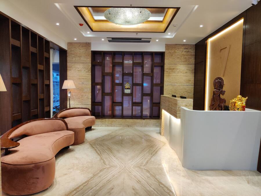 A modern reception area with a marble floor, a reception desk, and a seating area with cushioned chairs.