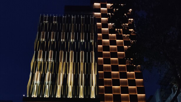 Un hotel moderno con un llamativo letrero iluminado que dice 'The SDYen Hotel'.