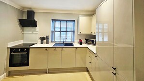 Cocina compacta con estufa, pileta y alacenas.