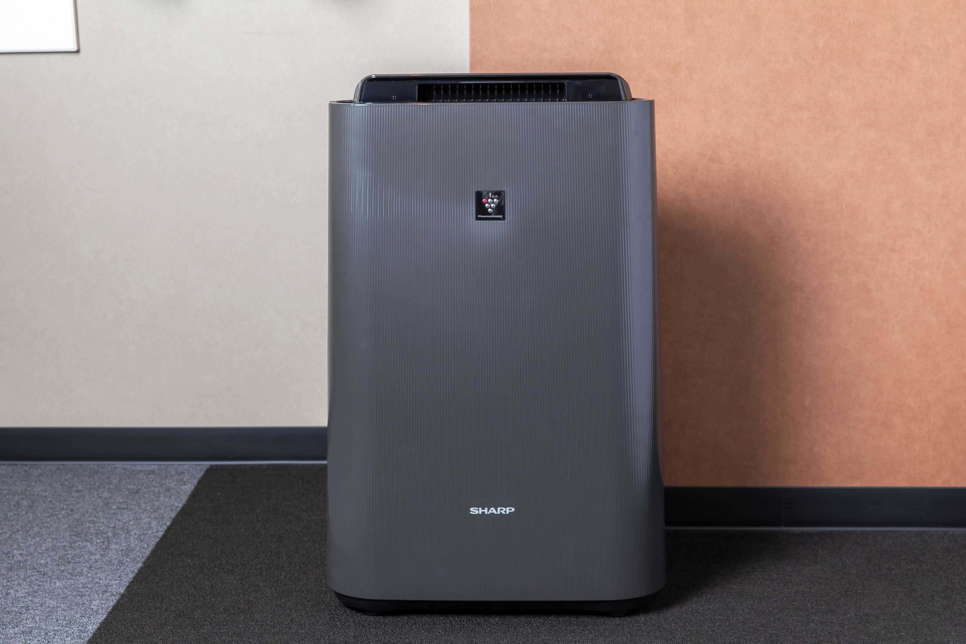 A gray, modern air purifier with a control panel and the brand name "SHARP" on the front.