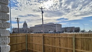 A fenced area with a building in the background. - The Capitol House (Oklahoma City)