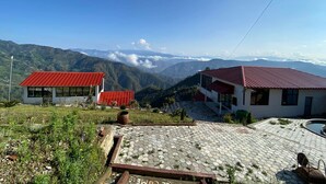 A view of a mountainous area with buildings featuring red roofs. - Sindhuligadhi Mountain Resort (Ratanchura)