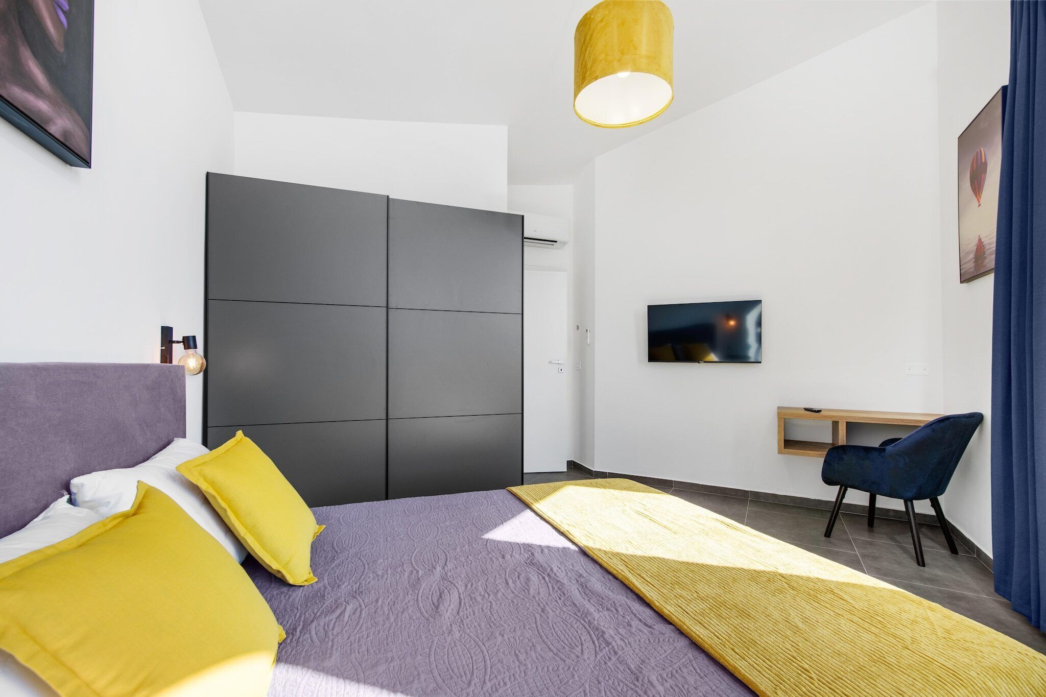 A modern bedroom with a bed, a desk, and a chair.