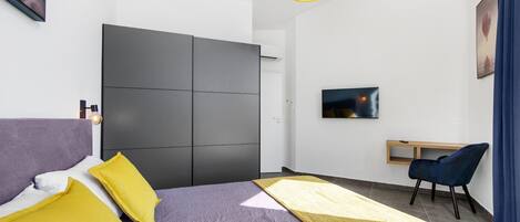 A modern bedroom with a bed, a desk, and a chair.