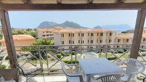 Un balcón con vistas a edificios y montañas.