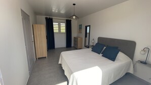 Une chambre à coucher avec un lit, une armoire, un miroir et un luminaire au plafond.