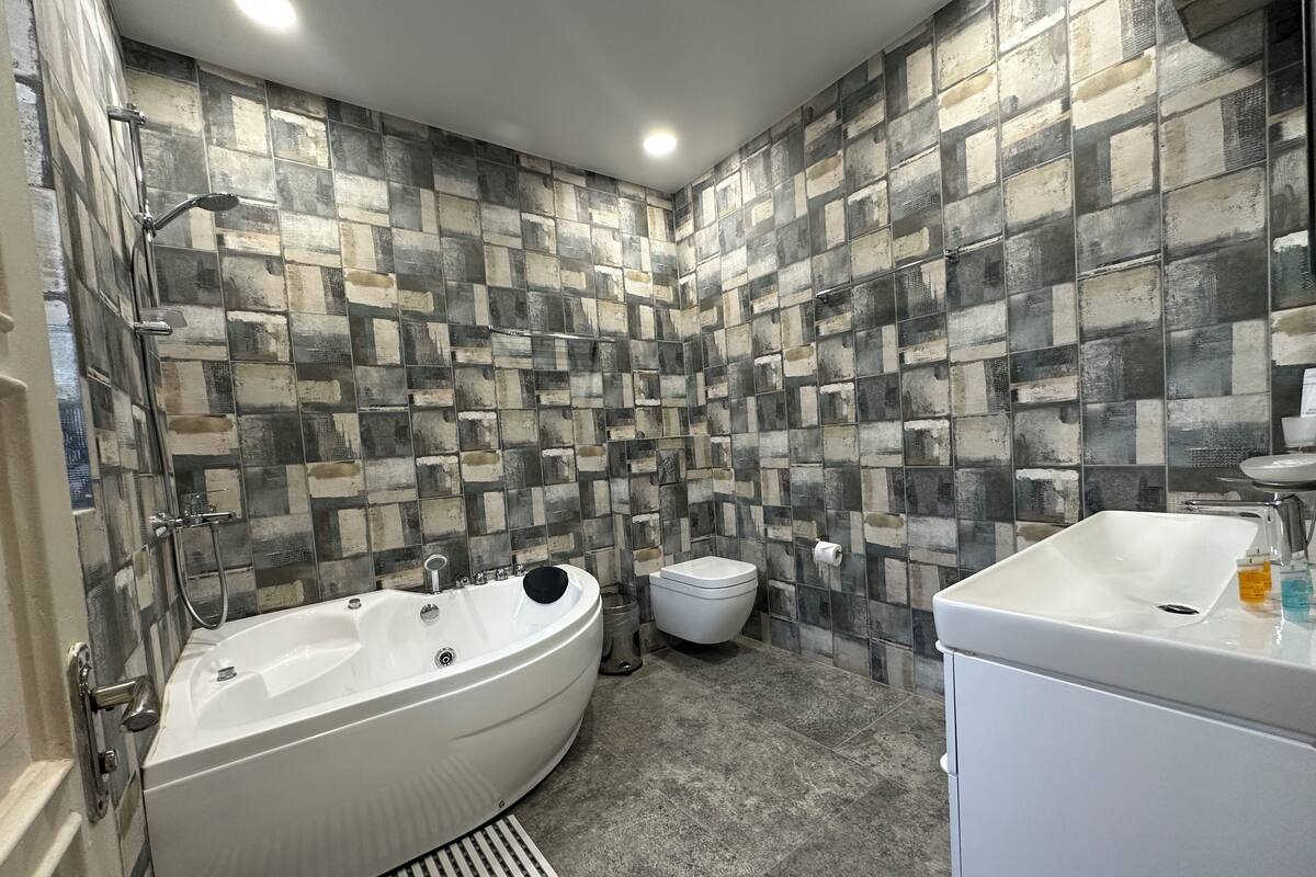 Une salle de bain moderne avec une baignoire sur pieds, des toilettes et un lavabo.