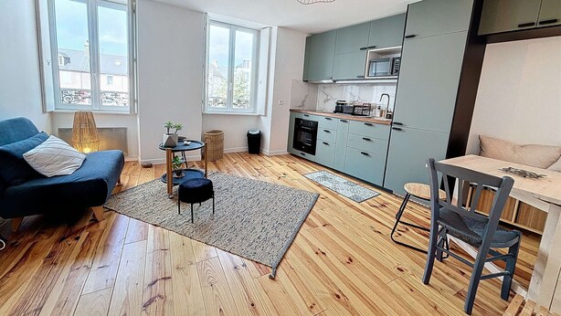 Un appartamento moderno con cucina, zona pranzo e angolo salotto.