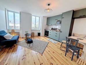 Apartamento moderno com cozinha, área de refeições e espaço para sentar.