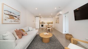 A modern living room with a sofa, coffee table, and artwork.