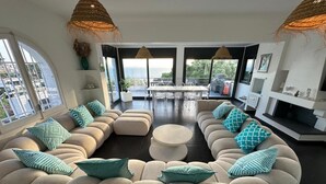 A modern living room with a sectional sofa, a round coffee table, and a fireplace.