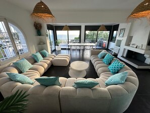 A modern living room with a sectional sofa, a round coffee table, and a fireplace.