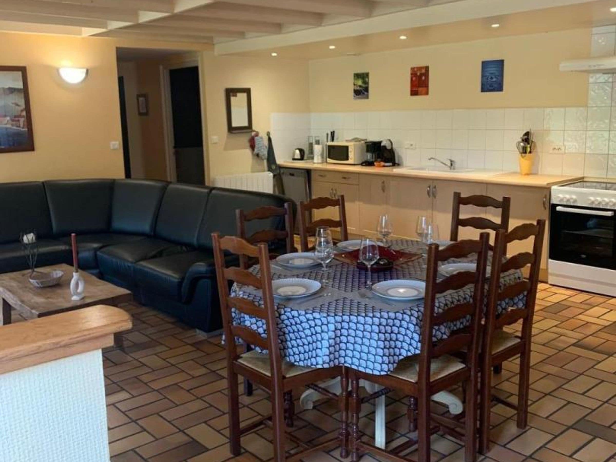 A dining area with a table set for four, surrounded by wooden chairs.