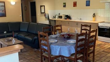 A dining area with a table set for four, surrounded by wooden chairs.