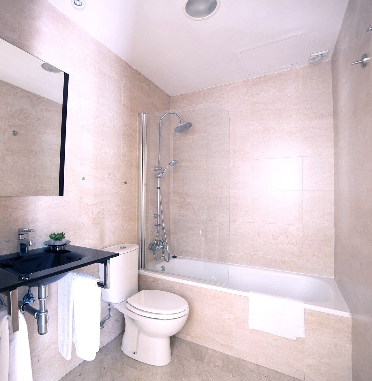 A modern bathroom with a bathtub, toilet, and sink.