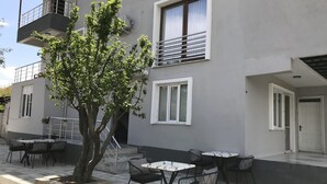 A building with outdoor seating, a tree, and a balcony. - Bavella House Pamukkale (Denizli)