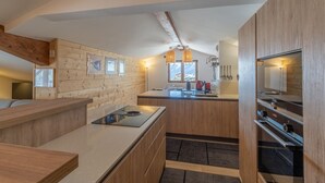 Ett modernt kök med träinredning, en köksö och en inbyggd ugn.