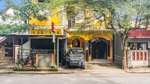 Un edificio amarillo con un garaje y una camioneta SUV estacionada.