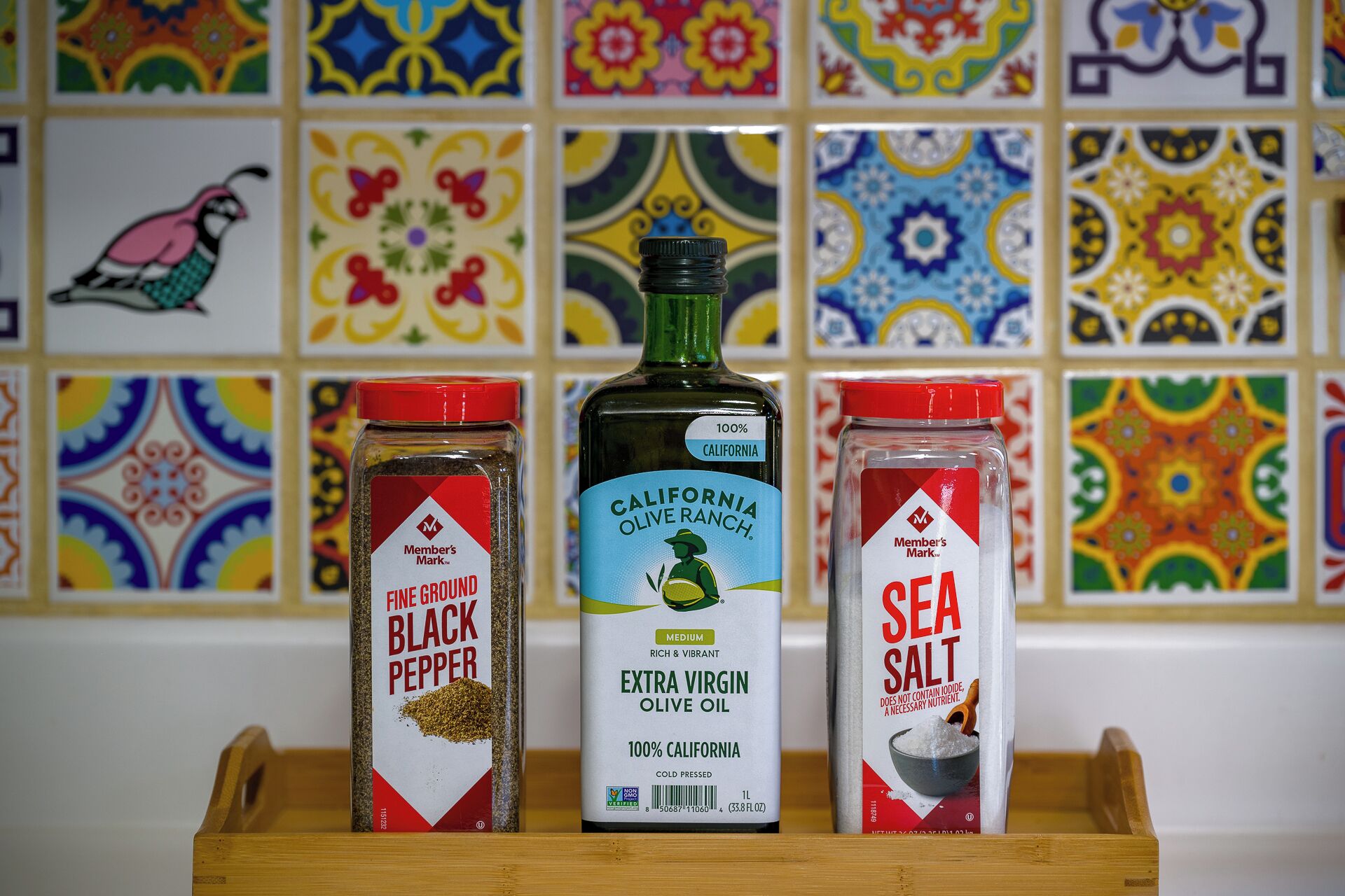 Three containers of spices on a wooden tray.