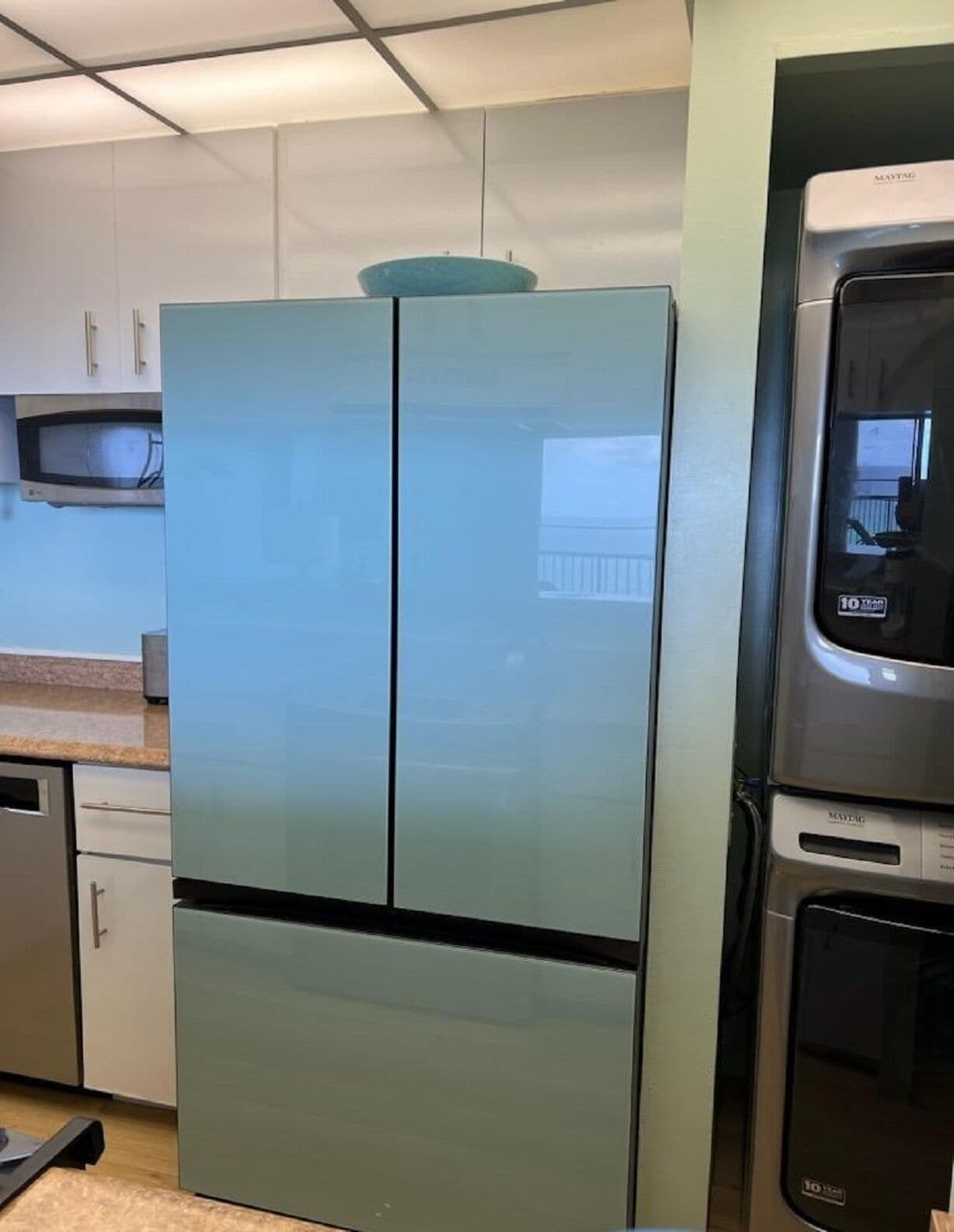 A kitchen with a large, modern refrigerator, a microwave, and a dishwasher.
