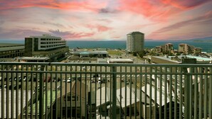 A view of a coastal cityscape with a prominent building and a parking lot. - Jisco Hotel Obama Onsen (Unzen)