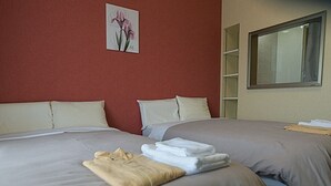 A hotel room with two beds, beige walls, a painting of flowers, and a window. - Jisco Hotel Obama Onsen (Unzen)