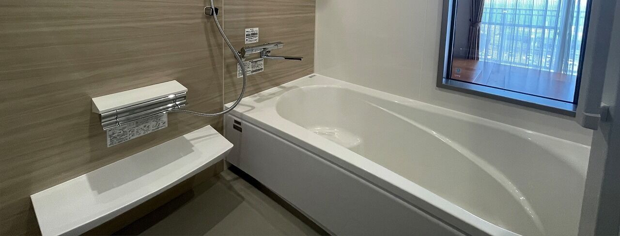 Un baño moderno con una bañera independiente, un tocador con espejo y un ventanal que proporciona luz natural.