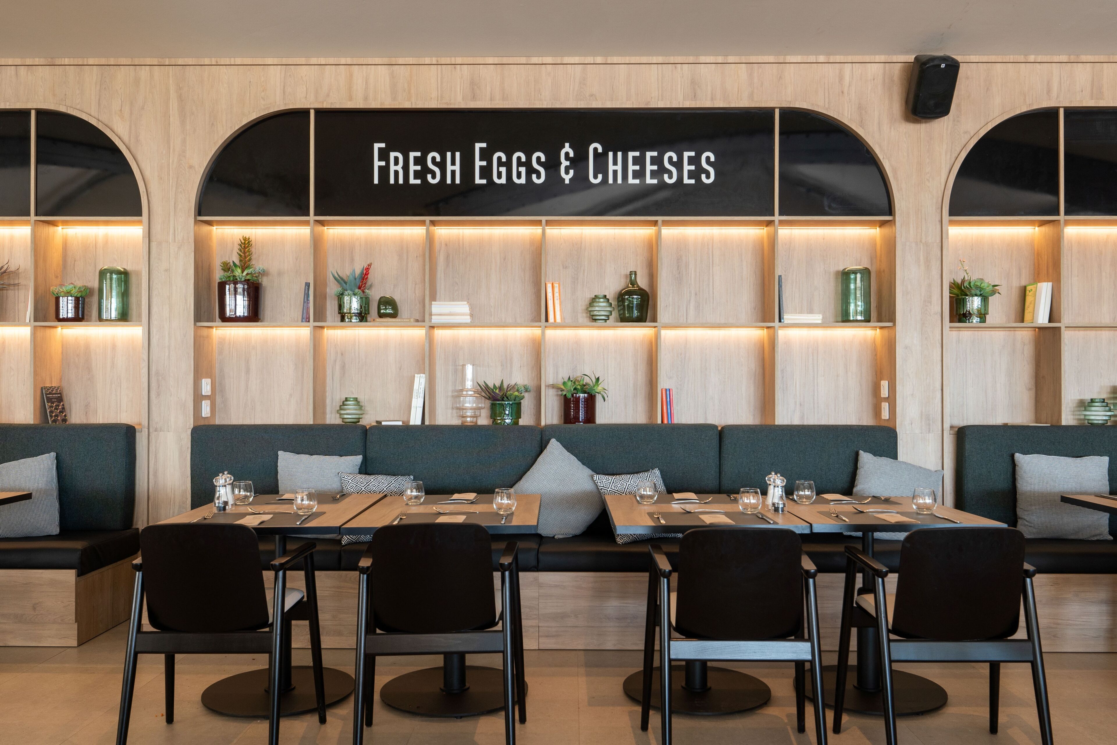 A restaurant with a long table and multiple seating options, including booths and chairs.