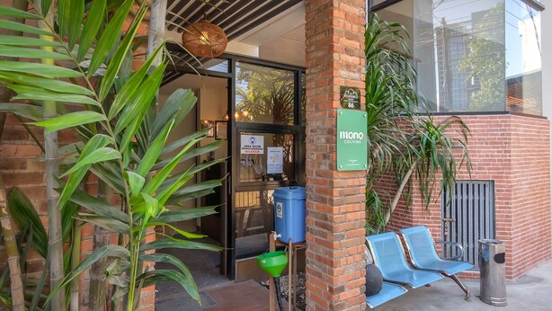 A building entrance with a sign for 'Monono Coliving' and a 'Masking Area' sign. - Mono Coliving Pakis, Surabaya (Surabaya)