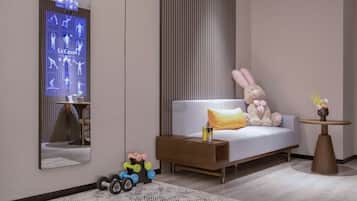 Una habitación de hotel moderna con un espejo grande, un sofá con un cojín, una mesita con un florero y un coche de juguete.