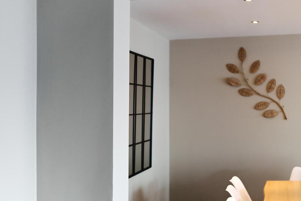 A modern interior with a minimalist design, featuring a wall-mounted art piece of a leaf branch and a framed picture.