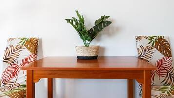 Una mesa de madera con una cesta tejida que contiene una planta verde.