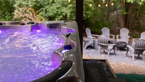 Un bain à remous avec vue sur l’espace extérieur aménagé et la verdure.