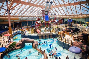 Un parc aquatique intérieur doté de plusieurs piscines, de toboggans et d’aires de jeux.