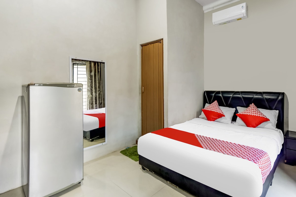 Een hotelkamer met een bed, een kledingkast, een spiegel en een raam.