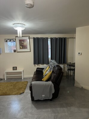 Relax in this inviting living space with a comfortable sofa, side table, and dining area.
