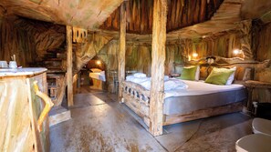 A rustic wooden room with a bed, a small table, and a chair. - Norrqvarn Hotel & Resort by Vänerport (Lyrestad)
