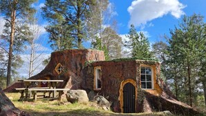 A rustic cabin with a wooden exterior, a black door, and a small window. - Norrqvarn Hotel & Resort by Vänerport (Lyrestad)