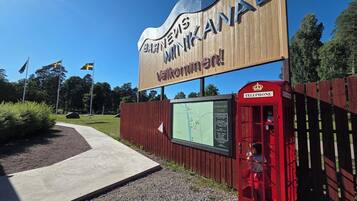 Un letrero con 'Västerås Minnecentrum' y una cabina telefónica roja.