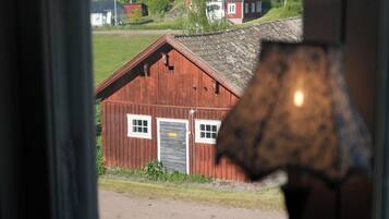 A red wooden building with a sloped roof, a door, and windows.