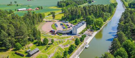 A riverside hotel with a parking area, a boat dock, and a landscaped garden.