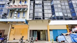 A multi-story building with a ground-level shop and parked motorcycles. - Hotel O Ringin Pitu 1 Syariah (Batam)