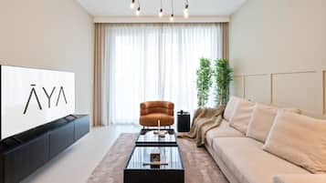 Departamento de lujo, 1 habitación | Área de sala de estar | Smart TV de 55 pulgadas con canales por cable, televisión y Netflix